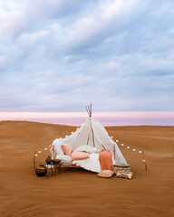 Romantic bed set up in the desert, by the sea, atmospheric weather conditions © Elnur