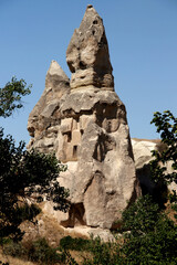 Photo with the view of the mountain with caves inside against a bright blue clear sky in the Pigeon Valley near the towns of Goreme and Uchisar in Cappadocia, Turkey