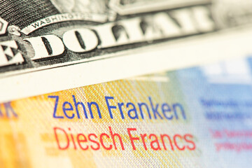 Obraz premium Über einem Schweizer Zehn Franken Geldschein liegt ein Zehn US-Dollar-Schein