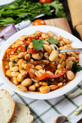 Lobio is a dish of Georgian, Azerbaijani and Armenian cuisines made from green bean pods. Lobio on a spoon. Traditional Georgian cuisine lobio. Lean dish. Lobio with pepper, onion. Side view.