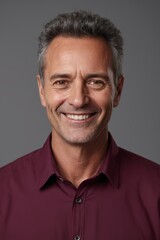 Obraz premium smiling man in a maroon shirt with a gray background