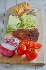 cutting board with ingredients to make a blackened fish sandwich
