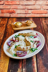 platter of bratwurst, grilled onions, and sauerkraut
