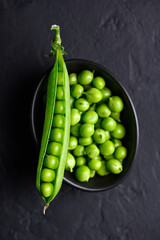 Top view of healthy green pea beans in a black bowl close up. Green pea beans vegetables. Food photography
