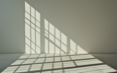 Fototapeta premium Sunlight streams through multi-paned window creating geometric shadows on the floor and white wall