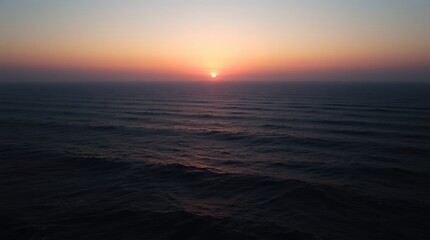Fototapeta premium Ocean Sunset Scene with Gentle Waves and Warm Light Glow