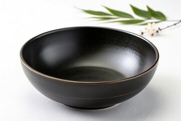Empty Black Ceramic Bowl Showcasing Simplicity on a White Background With Subtle Greenery Generative AI