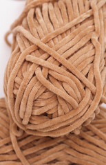 Skeins of beige yarn on a white background