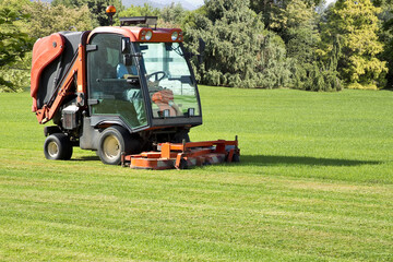 Professional motorized ride on lawn mower cutting fresh grass