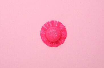 Miniature doll hat on pink background