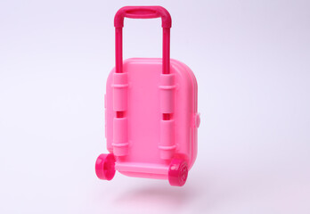 Miniature travel doll luggage floating on a white background