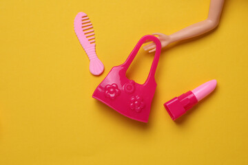 Doll accessories on yellow background. Beauty and fashion, travel concept. Flat lay