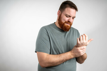 Closeup of man arms massaging painful wrist after work on laptop computer at home, suffering from...