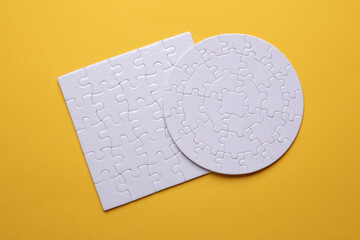 White blank Jigsaw puzzles of different shapes on a yellow background