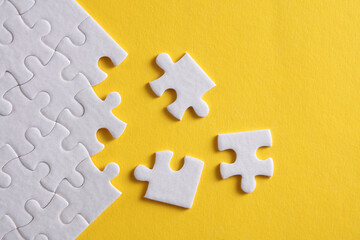 White blank square Jigsaw puzzle pieces disassembled.on yellow background. Mockup for design