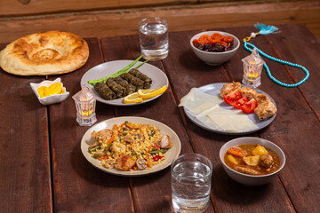 Set table for iftar in Ramadan, water, finii, dolma, khinkal and stewed lamb with potatoes. Horizontal photo.