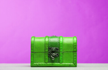 Green wooden pirate chest on a pink .background