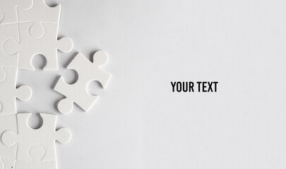 White jigsaw puzzle pieces on a gray background. Your text, copy space for information