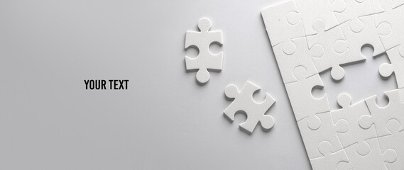 White jigsaw puzzle pieces on a gray background. Your text, copy space for information