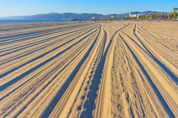 Fototapeta premium Tracks in the Sand at Venice Beach Under Clear Blue Sky