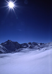 Snow-capped Valtellina mountain photographed in winter against the sun