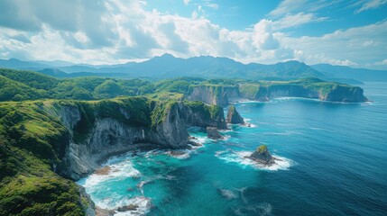 Fototapeta premium Coastal cliffs and ocean waves. Green plants grow atop rocks with mountains and clouds in background. Beautiful landscape with blue water. Peaceful and scenic nature view.