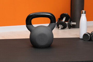 Fototapeta premium One kettlebell on mat indoors. Sport equipment