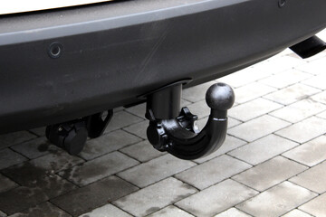 Close up towbar on car. Tow bar of passenger car. Car hook for trailer. Black SUV tow hitch. Trailer hitch or towbar on black vehicle. Tow hitch for towing a trailer.