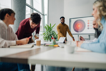 Marketing team analyzing global market data during office presentation