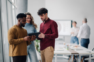 Business people using tablet and discussing work in modern office