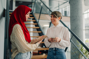 Two businesswomen discussing work in modern office building
