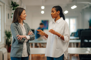 Two businesswomen talking during coffee break in office