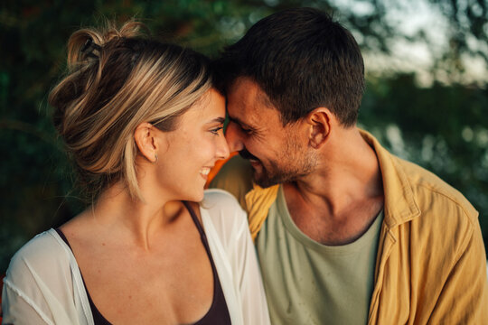 Happy couple sharing a tender moment outdoors, enjoying intimacy and love