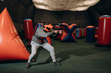 The player bends down and quickly changes position to avoid being hit. Brightly colored barricades...