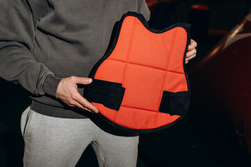 An orange vest made of very durable paintball fabric that is issued to the player on the field for...