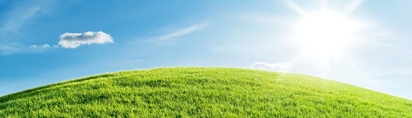 Obraz premium Bright Morning Sunrise Concept with Sun Rising Over Green Hill and Clear Blue Sky