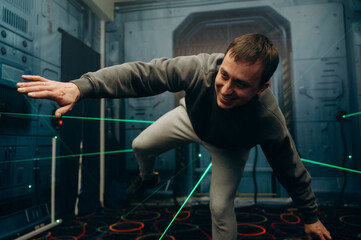 The player reaches forward, carefully stepping between the intersecting laser lines. Every move...