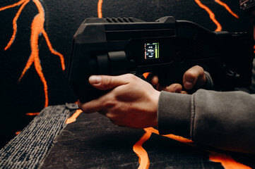 The player holds a laser pistol in his hands, preparing to fire a shot. Vivid weapon details and a...