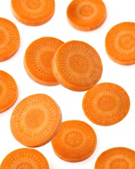 Fresh orange carrot slices arranged in a pattern on a white background, healthy vegetable for salads and cooking, isolated on white.