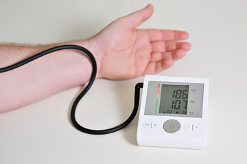 Electronic blood pressure monitor and male hand