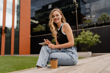 Fototapeta premium young pretty woman sitting in student campus co-working outside