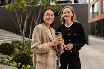 young pretty women walking talking in street doing business