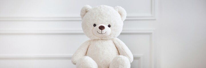 Obraz premium A white bear sitting gracefully on a snow-white background. The room in the background is immaculately decorated in a minimalist style. A banner with a place to copy it.