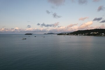 Boats peacefully anchored in a beautiful bay during sunset near a coastal town