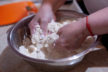 Hands mixing flour and butter in a bowl for homemade dough
