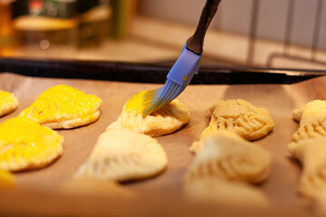 Brushing egg wash on homemade pastries before baking
