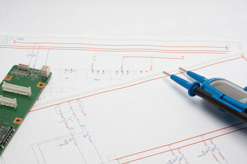 Electronic circuit board and voltage tester on technical blueprint
