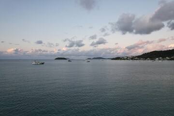 Calm waters and boats at sunset near a coastal village