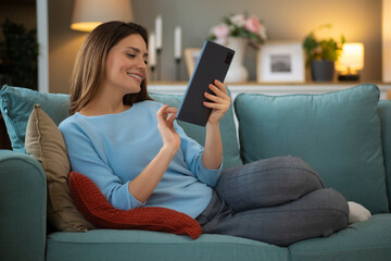  Beautiful woman using digital tablet at home