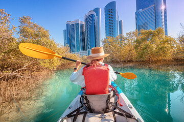 Tourist paddling on a kayak in mangrove Al Reem island mangrove park in Abu Dhabi, United Arab Emirates